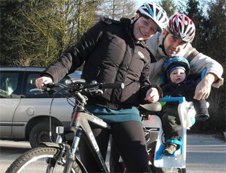 Mutter und Vater mit Kind am Fahrrad unterwegs